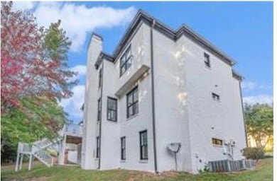 View of side of home featuring a chimney and stucc