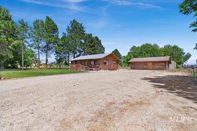 Cabin featuring a garage and an outbuilding