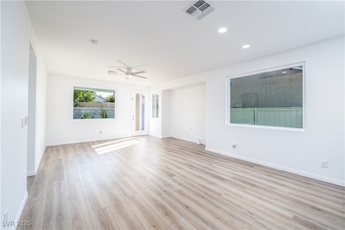 Unfurnished room featuring a ceiling fan, light wo