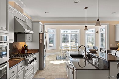 Kitchen with crown molding, an island with sink, s