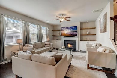 Living room featuring dark hardwood / wood-style floors and ceiling fan