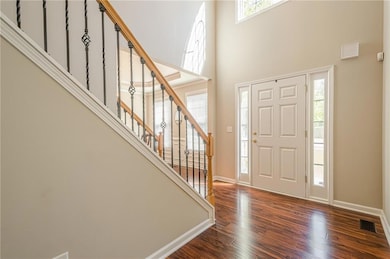 Entryway with a towering ceiling, wood finished fl