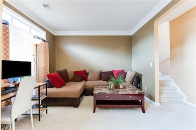 Carpeted living room with ornamental molding