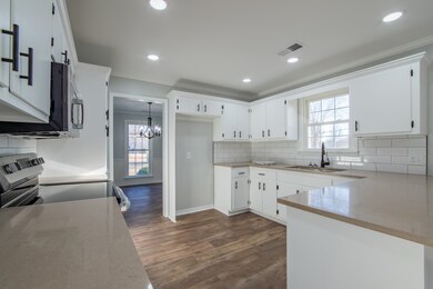 Kitchen featuring white cabinetry, sink, dark wood