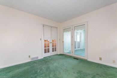 Carpeted spare room with french doors