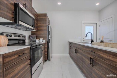 Kitchen featuring dark brown cabinetry, sink, backsplash, and stainless steel appliances