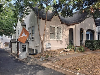 View of front facade with stucco siding, covered 