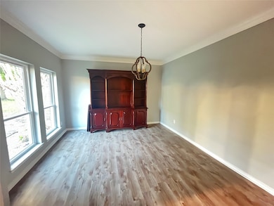 Unfurnished dining area with light wood-style floors, a chandelier, and ornamental molding