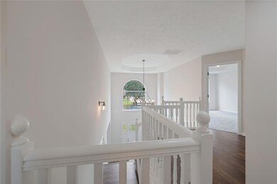Corridor featuring an upstairs landing, a chandelier, wood finished floors, and a textured ceiling