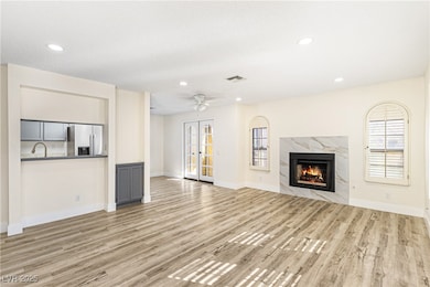 Unfurnished living room featuring a high end fireplace, light wood-style floors, recessed lighting, and ceiling fan