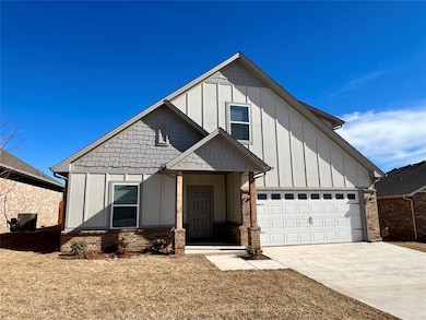 View of front facade featuring concrete driveway, board and batten siding, an attached garage, and brick siding