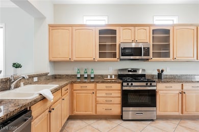 Kitchen with light brown cabinets, stainless steel
