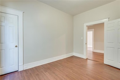 Unfurnished room featuring wood finished floors and baseboards