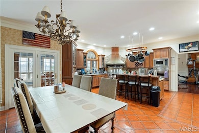 Dining room with crown molding, a chandelier, light tile patterned floors, and recessed lighting
