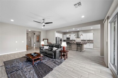 Living area with a ceiling fan, light wood-style f