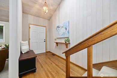 The front entry is defined with gorgeous oak hardwood floors with wood-lined walls and ceilings.
