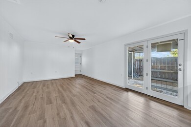 Empty room featuring light wood-style flooring, ornamental molding, and a ceiling fan
