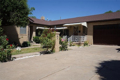 Single story home featuring brick siding, a garage, driveway, a chimney, and a shingled roof