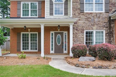 Doorway to property with stone siding and a porch