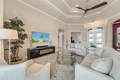 Tiled living room featuring a tray ceiling, french