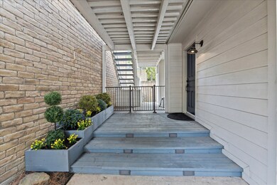 The inviting entryway showcasing these beautiful planter boxes is located on the side of the home. Access to the fully fenced backyard is through the wrought iron gate ahead.