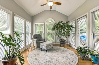 Sunroom featuring vaulted ceiling and wood finished floors