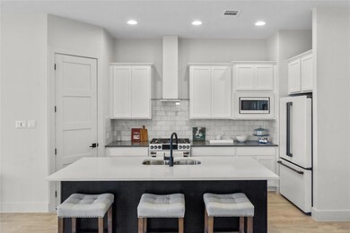 Kitchen featuring white appliances, wall chimney 
