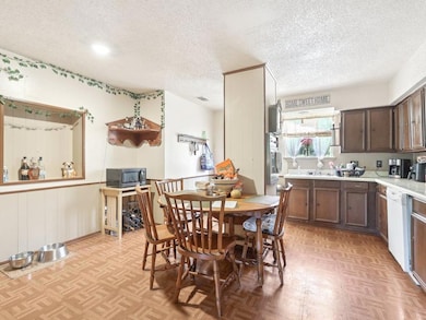 Kitchen with a textured ceiling, black microwave,