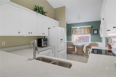 Kitchen featuring white cabinets, sink, hanging li