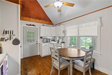 Dining space with vaulted ceiling, dark wood-type flooring, and a ceiling fan