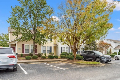 View of property hidden behind natural elements featuring uncovered parking