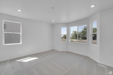Carpeted empty room with recessed lighting