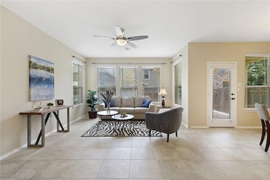 Living room featuring light tile patterned floors and ceiling fan