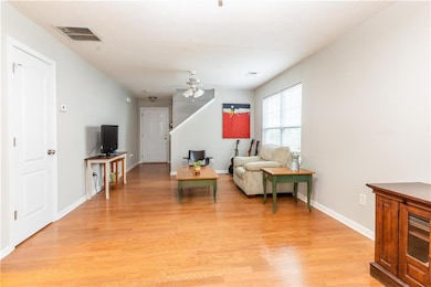 Living area featuring baseboards, a ceiling fan, l