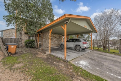 View of parking with concrete driveway and fence