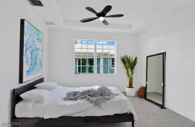 Carpeted master bedroom featuring a raised ceiling