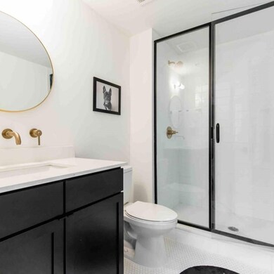 Bathroom featuring toilet, a shower with door, van