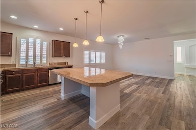 Kitchen with dishwasher, a sink, wood finished flo