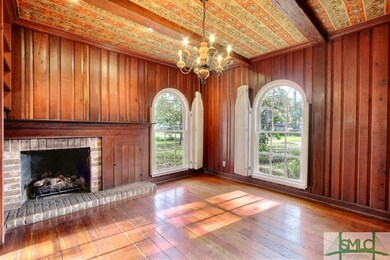 Paneled Den on front of house has fireplace with g