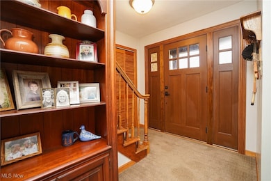Carpeted entryway with stairway