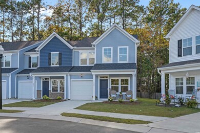 Traditional-style home featuring concrete driveway, roof with shingles, and a garage