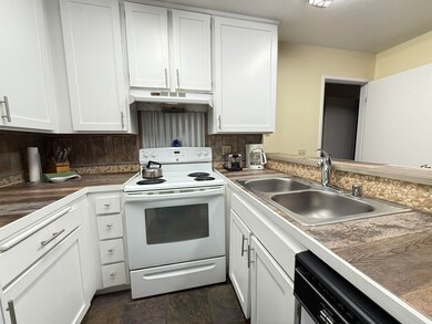Kitchen featuring white cabinets, white electric range and oven