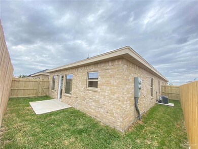 Back of house with brick siding, a lawn, cooling unit, and a fenced backyard