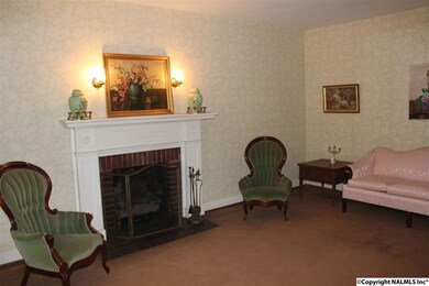 Gas logs in a fireplace framed by a vintage mantle.