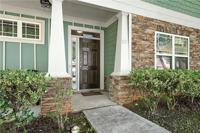 Doorway to property with stone siding and a porch