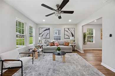 Living area with plenty of natural light, wood finished floors, a ceiling fan, and recessed lighting