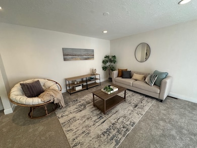 Living area featuring carpet, recessed lighting, and a textured ceiling