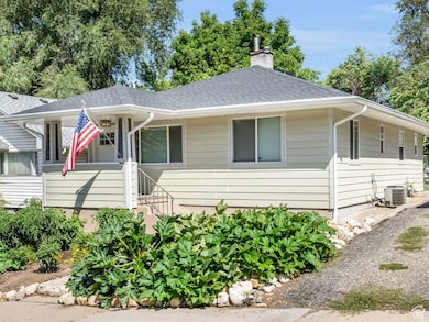 View of front of house featuring a shingled roof and a chimney