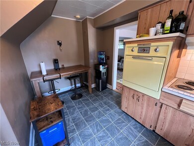 Kitchen with tasteful backsplash, white appliances, ornamental molding, and dark tile flooring