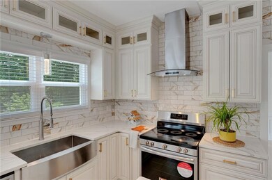 Kitchen featuring wall chimney exhaust hood, stain